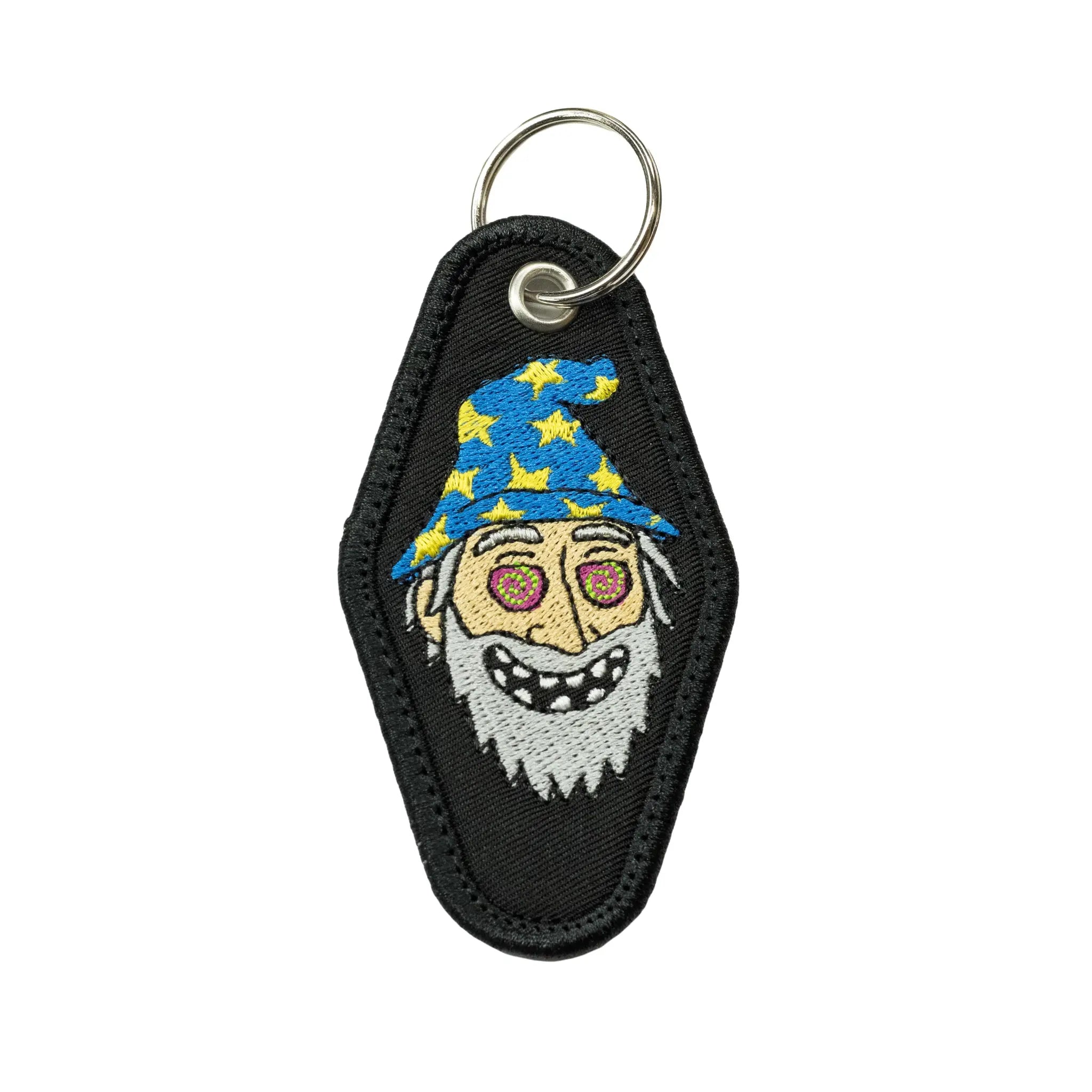 Front view of a black diamond-shaped motel keychain by Regular Magic featuring an embroidered Freaky Wizard character with a blue star-patterned hat and spiral eyes.