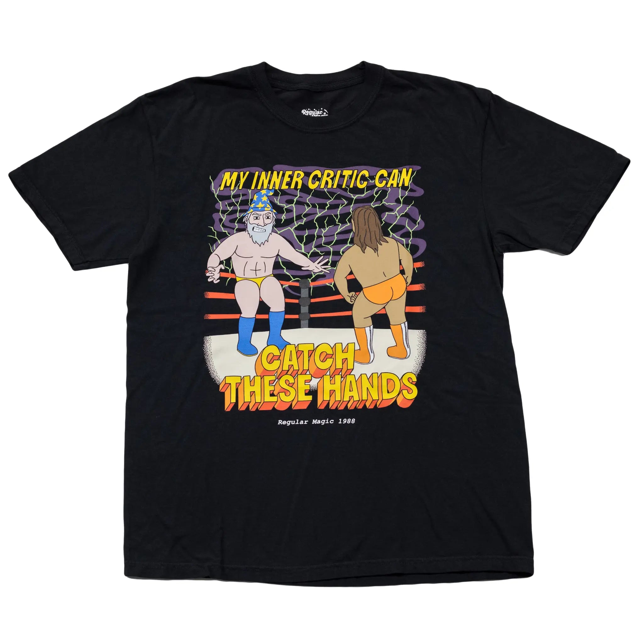 Front view of a black t-shirt by Regular Magic featuring Wizard as a wrestler in a ring facing off against his opponent, with text reading 'MY INNER CRITIC CAN CATCH THESE HANDS'.