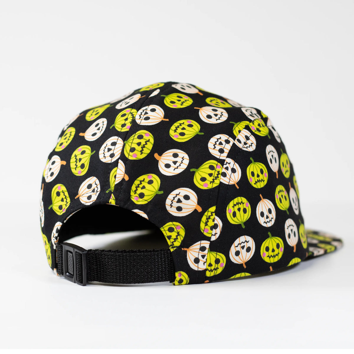 Back view of a black 5-panel camper hat featuring an all-over lime green and white jack-o'-lantern print with a black adjustable nylon strap closure.