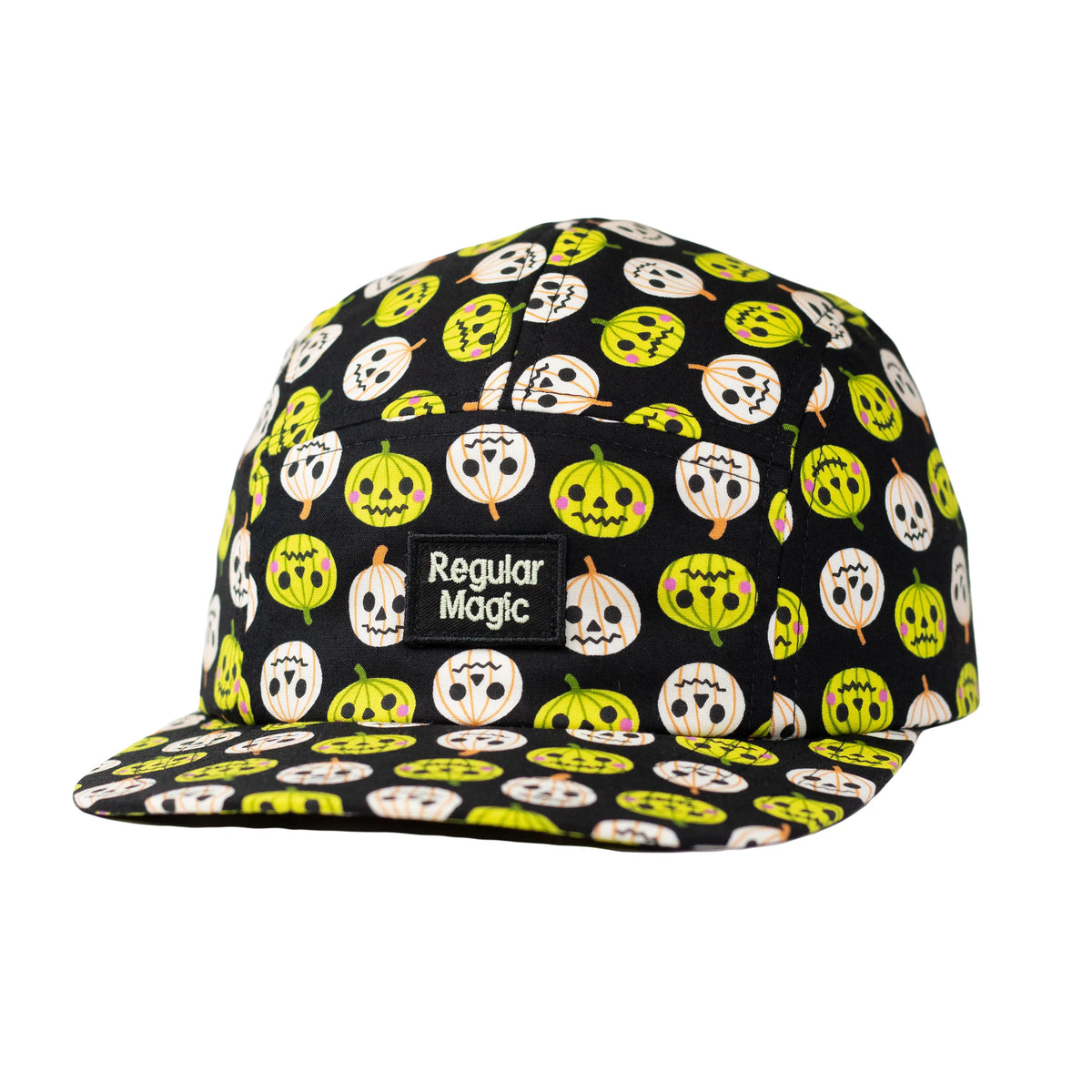 Front view of a black 5-panel camper hat by Regular Magic featuring a lime green and white jack-o'-lantern pattern and an embroidered glow in the dark logo patch.