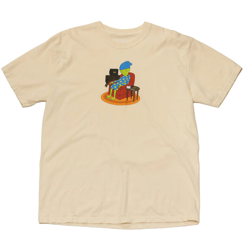 Front view of a beige cotton t-shirt by Regular Magic featuring a center graphic of the Sleepy Alien character relaxing in a cozy room setting.