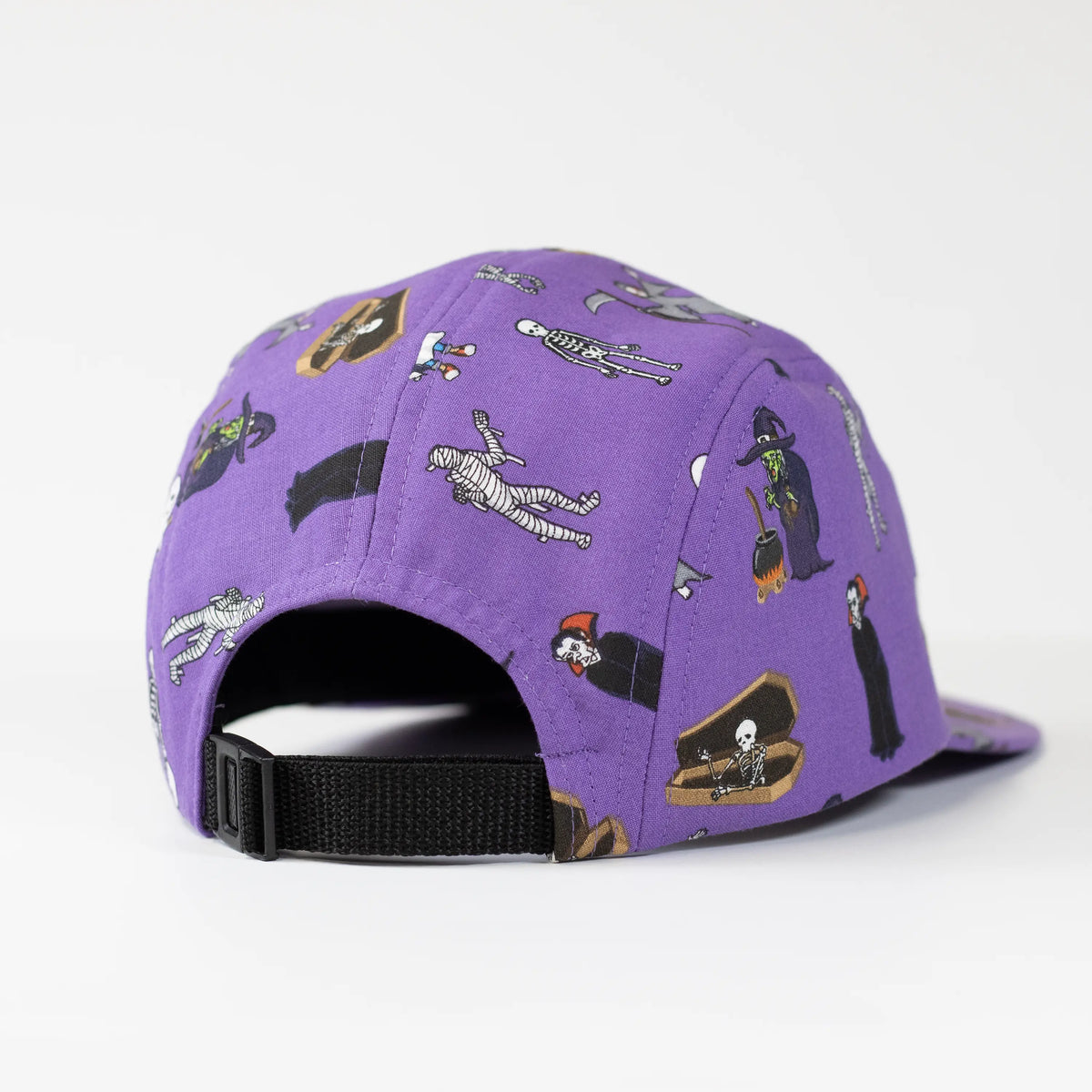 Back view of a purple 5-panel camper hat featuring a Halloween monster print with a black adjustable strap closure.