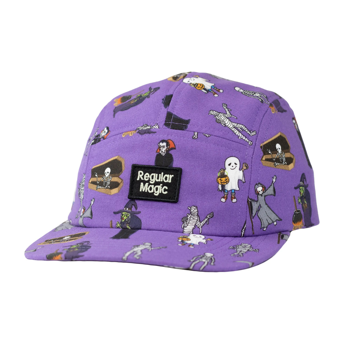 Front view of a purple 5-panel camper hat by Regular Magic with an all-over trick-or-treat monster print and a black embroidered, glow in the dark logo patch.