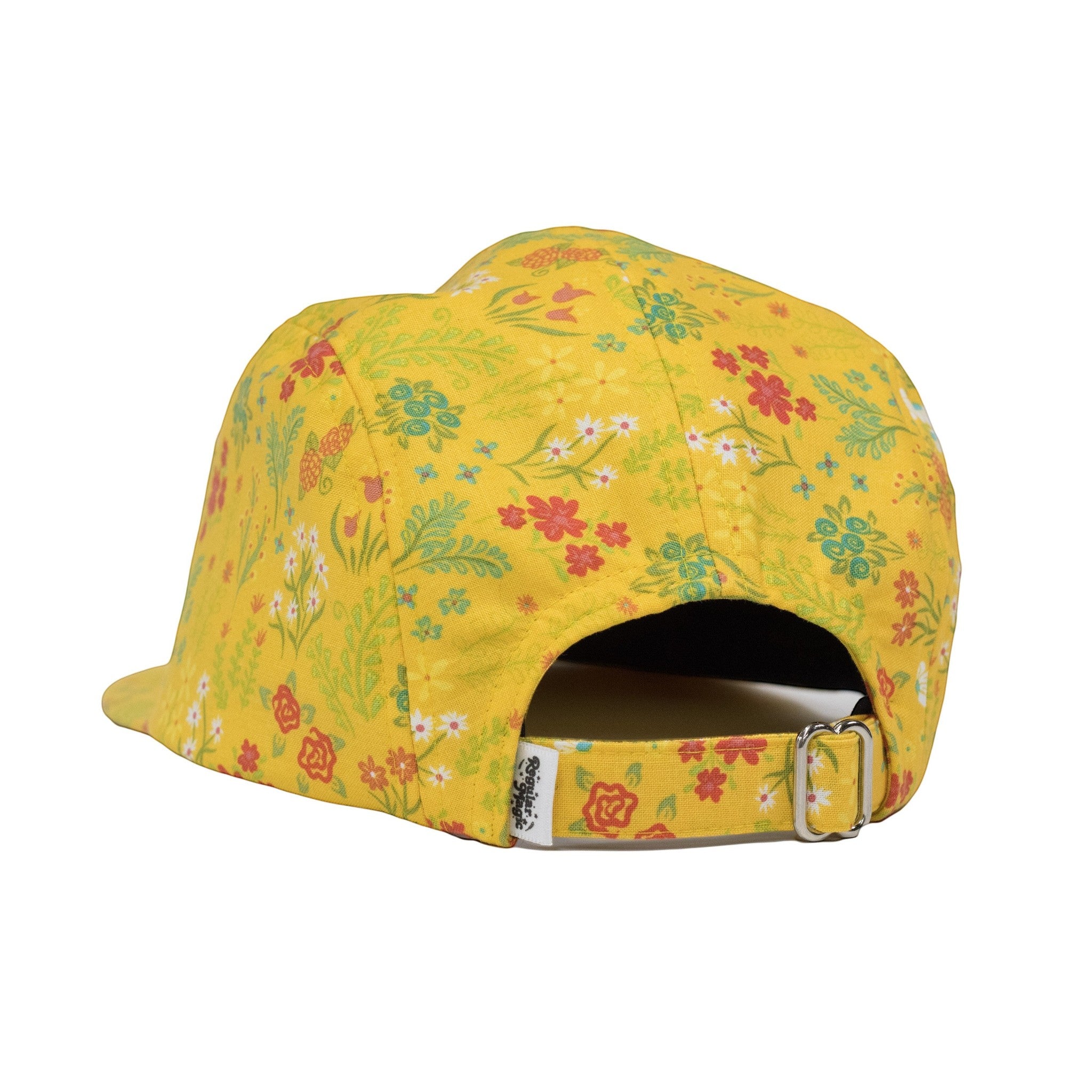 Back view of Regular Magic yellow floral 5-panel camp cap showing adjustable fabric strap, metal buckle, and woven brand tag.